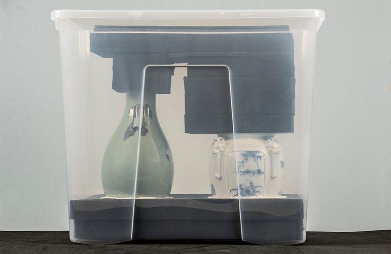 A ceramic vase and cup packaged in a plastic container. They are supported by layers of foam.